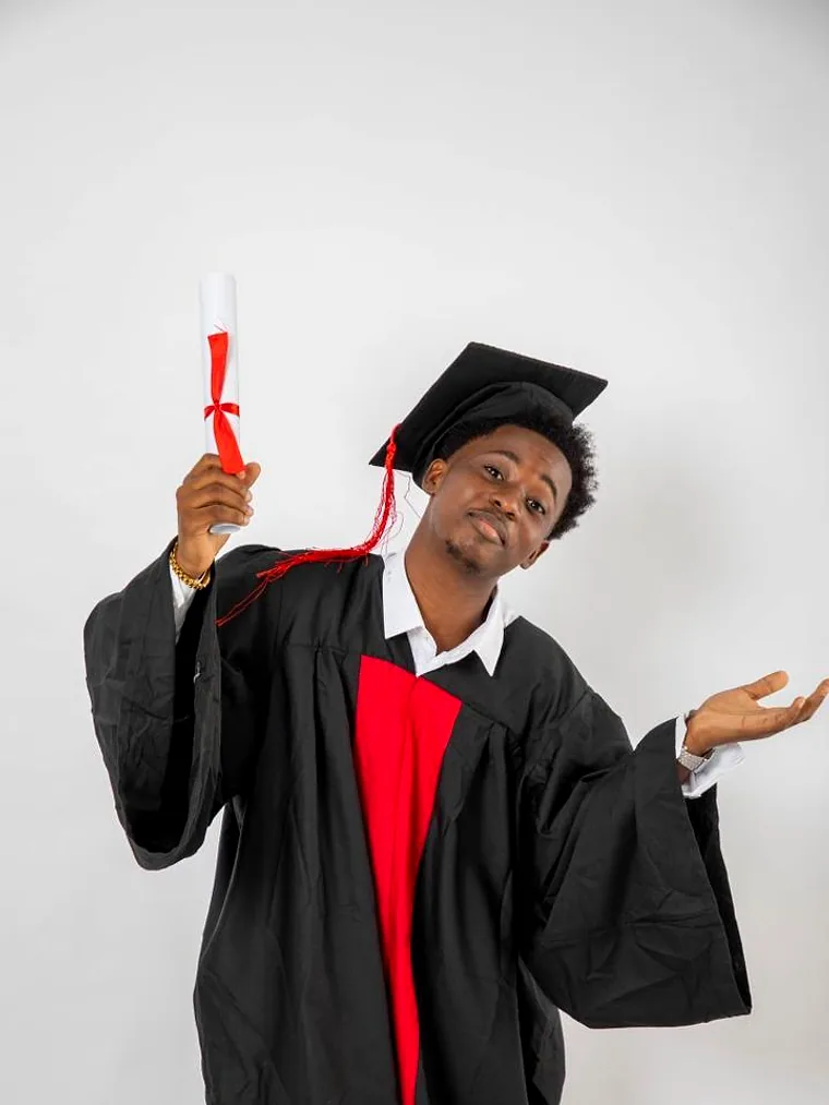 Portrait d'un diplômé en toge, le poing levé